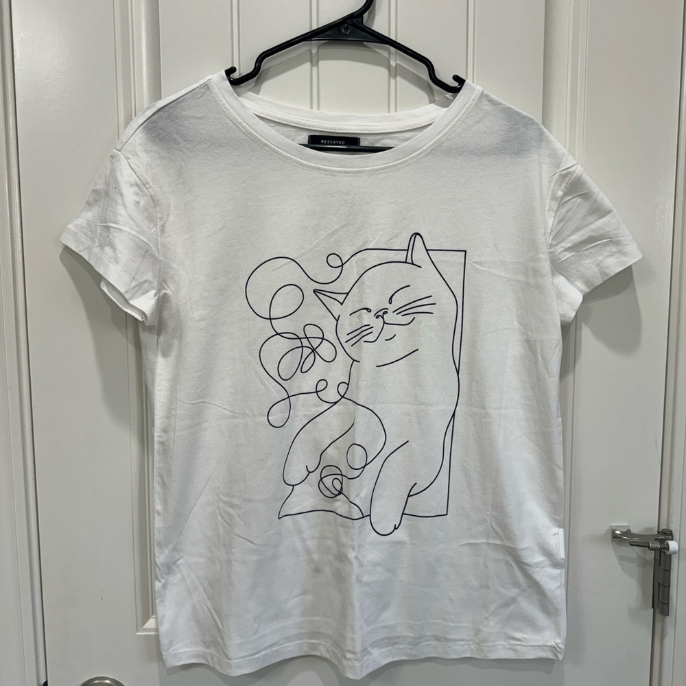 White t-shirt with a cute cat line drawing on it
